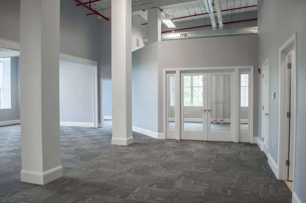 Finished office suite in a converted Fall River mill with high ceilings and glass doors